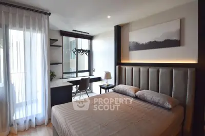 Modern bedroom with elegant decor and natural light, featuring a cozy bed and stylish workspace.