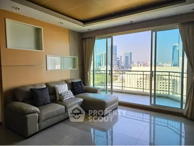 Spacious living room with modern sofa and stunning city view from large windows.