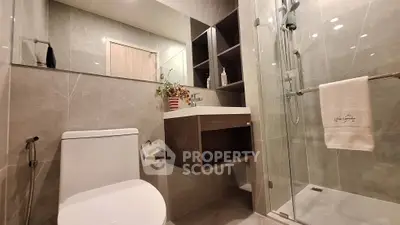 Modern bathroom with sleek design, glass shower, and elegant fixtures in a luxurious real estate property.