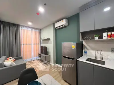 Modern living room with kitchen featuring sleek appliances and stylish decor