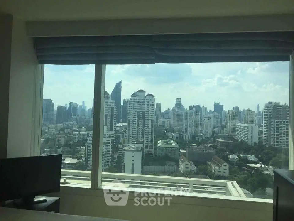 Stunning cityscape view from a high-rise apartment window, showcasing urban skyline.