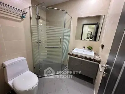 Modern bathroom with glass shower and sleek vanity in a contemporary home.
