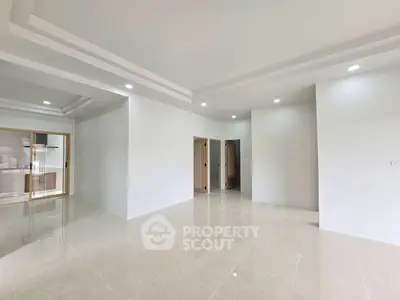 Spacious modern living room with sleek tile flooring and recessed lighting