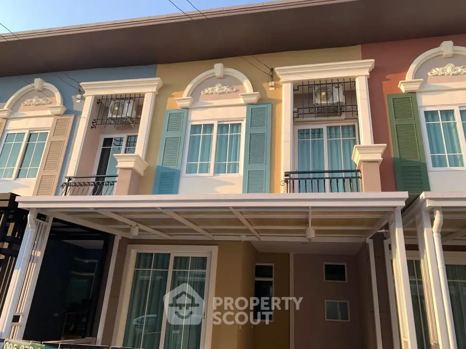 Charming townhouse exterior with colorful facade and decorative window shutters.