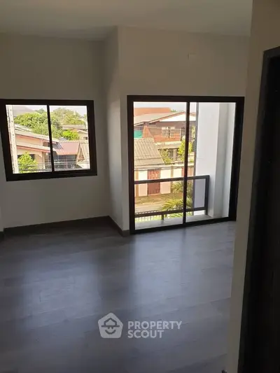 Spacious room with large windows offering a view of the neighborhood, perfect for natural light lovers.