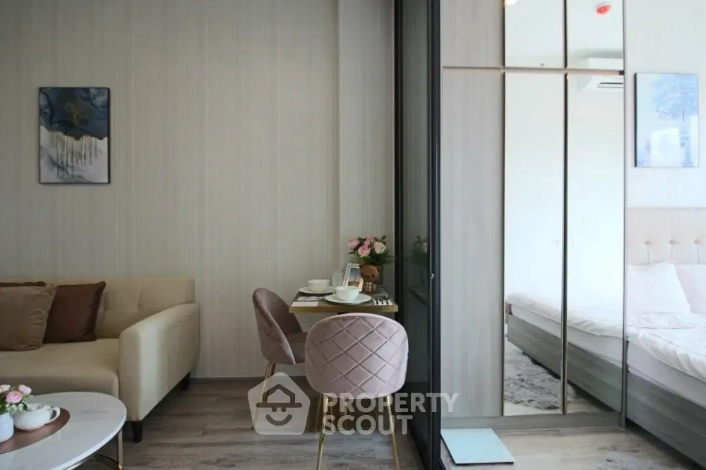 Modern living room with cozy seating and dining area adjacent to a stylish bedroom.