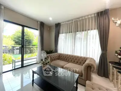 Elegant living room with large windows and stylish furniture, offering a bright and inviting atmosphere.
