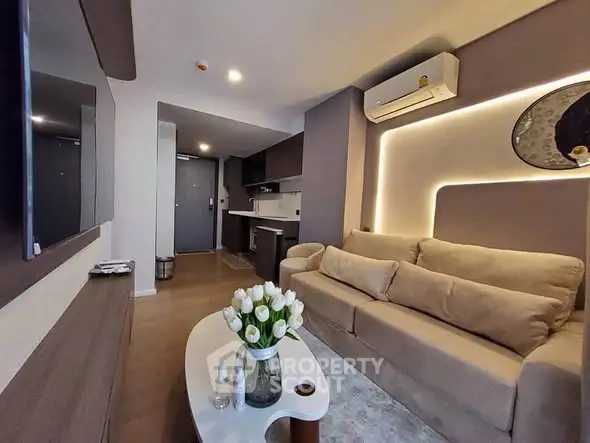 Modern living room with cozy beige sofa, stylish decor, and sleek open kitchen layout.