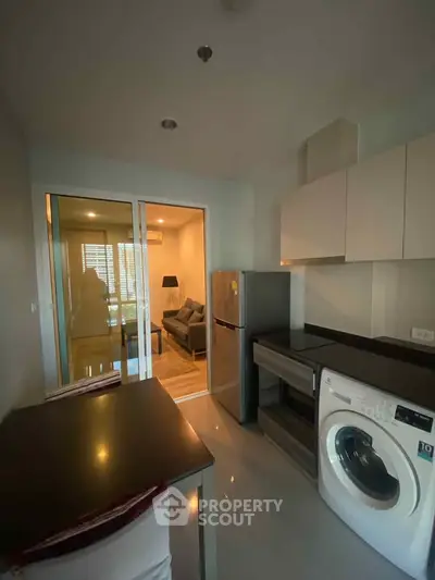 Modern kitchen with washing machine and fridge in sleek apartment
