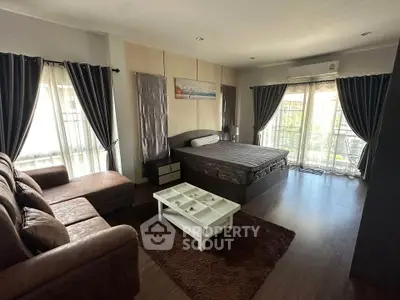 Spacious bedroom with modern decor and large windows for natural light