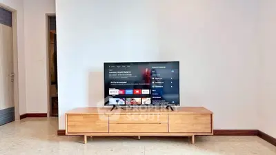 Modern living room with sleek wooden TV stand and flat-screen TV displaying streaming apps.