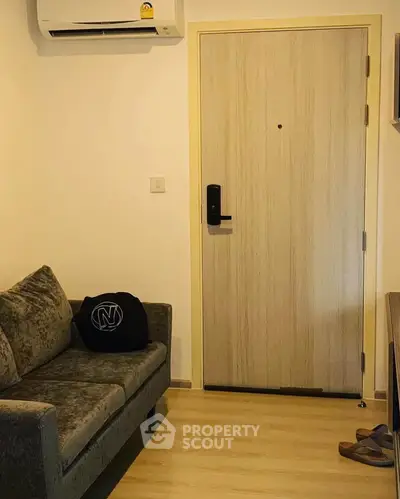 Cozy living room with modern sofa and secure door in stylish apartment.