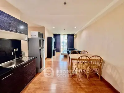 Spacious open-plan living and dining area with modern kitchen and wooden flooring.