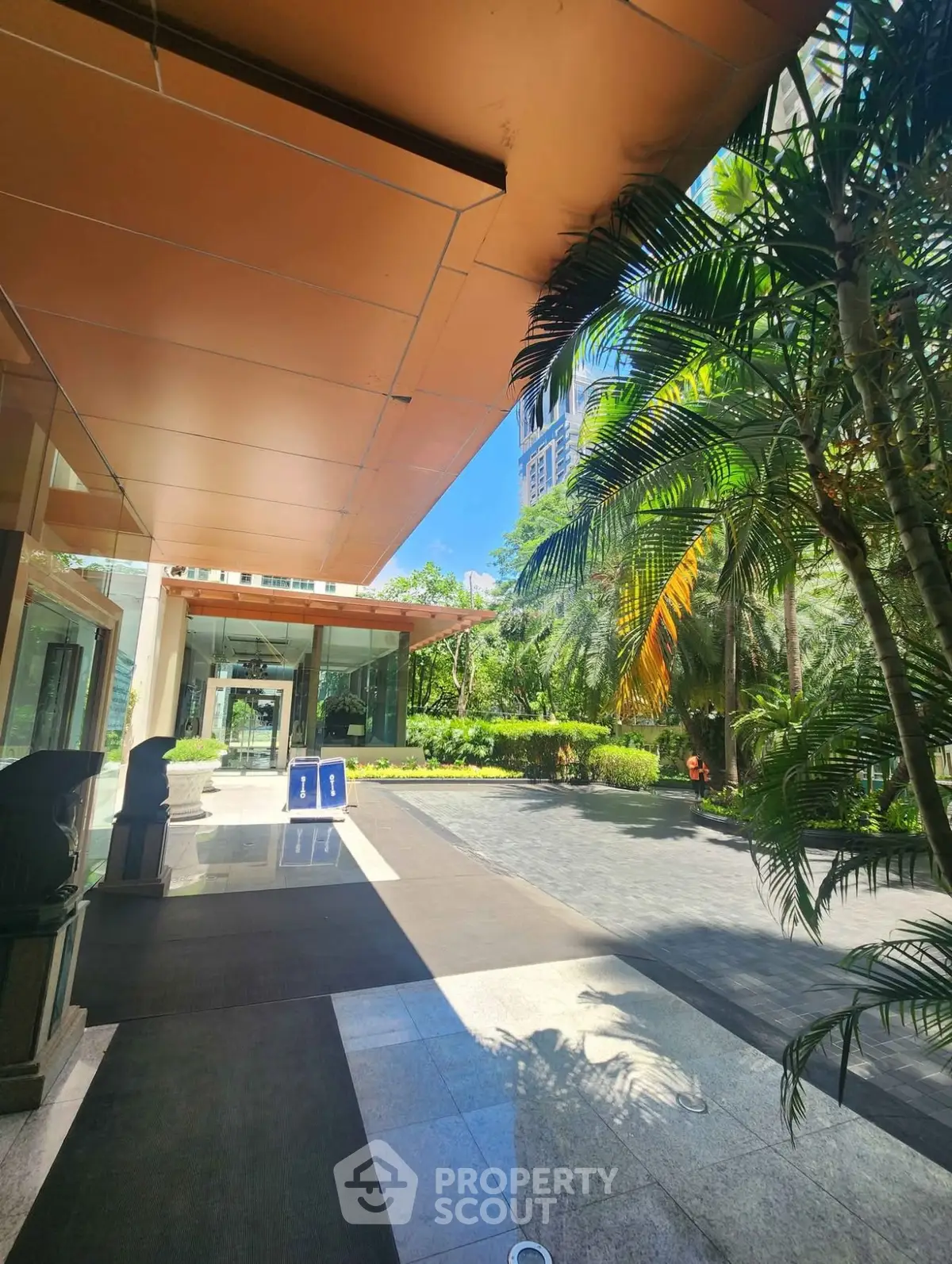 Luxurious building entrance with lush garden and modern architecture