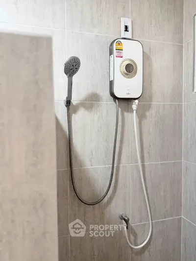 Modern bathroom with sleek shower unit and neutral tile design.