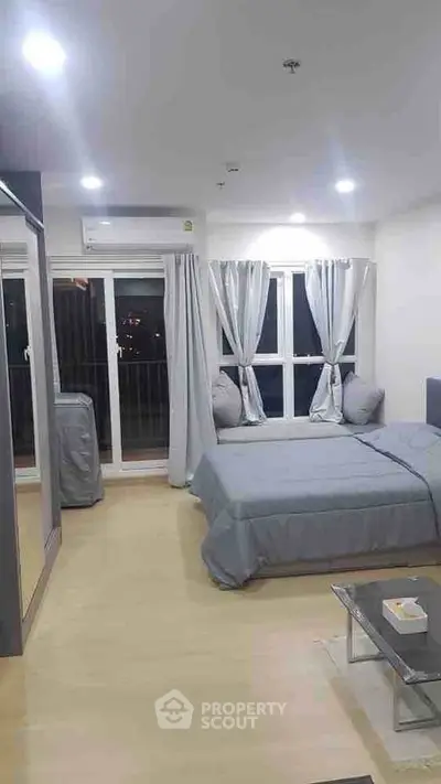 Modern bedroom with large windows and stylish decor in a contemporary apartment.