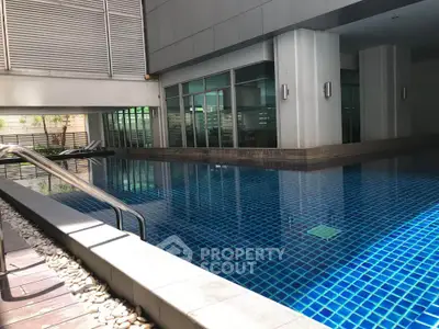Luxurious indoor swimming pool in modern residential building with sleek design and ambient lighting.