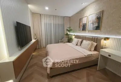 Luxurious bedroom with modern decor and large TV, perfect for relaxation.