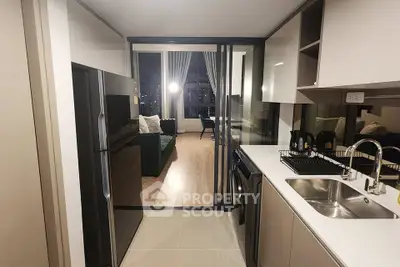 Modern open-layout kitchen with sleek appliances and view into stylish living room