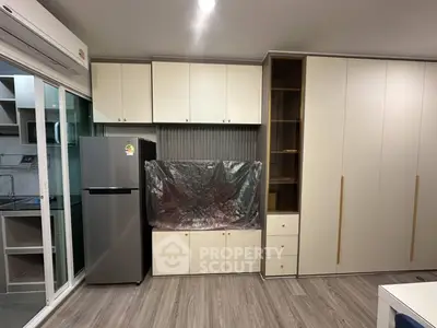 Modern kitchen with sleek cabinetry and stainless steel fridge in a stylish apartment.