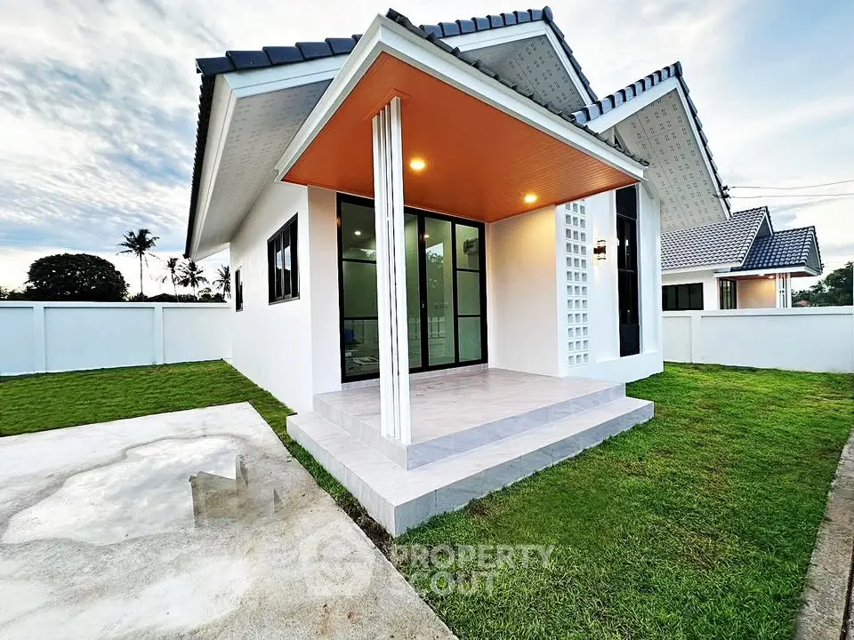 Charming modern house with sleek design, spacious lawn, and inviting entrance in a serene neighborhood.