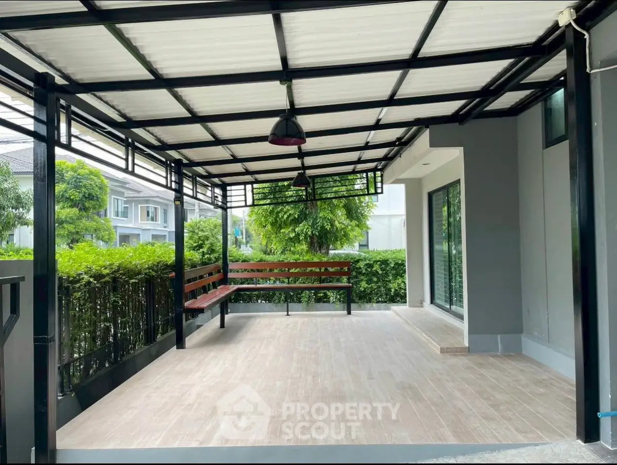 Spacious covered patio with modern design and garden view, perfect for outdoor relaxation.