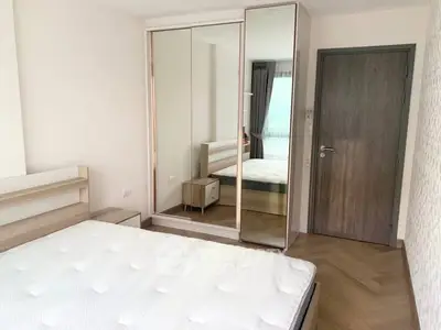 Modern bedroom with mirrored wardrobe and wooden flooring