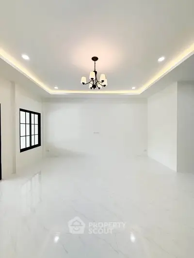 Spacious modern living room with elegant chandelier and large windows