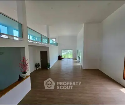 Spacious modern living room with high ceilings and large windows offering natural light.