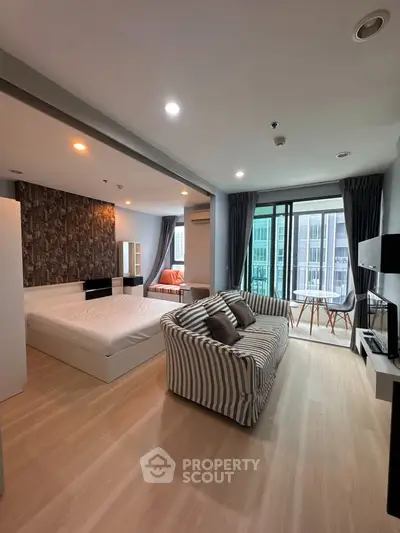 Spacious modern studio apartment with stylish decor and balcony view