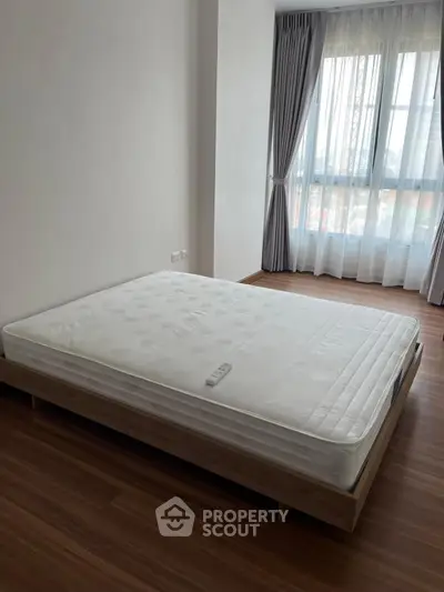 Spacious bedroom with large window and modern minimalist design