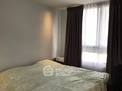 Cozy bedroom with large window and elegant curtains, perfect for relaxation and comfort.