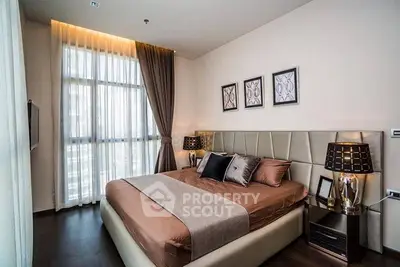 Luxurious modern bedroom with elegant decor and large window for natural light.