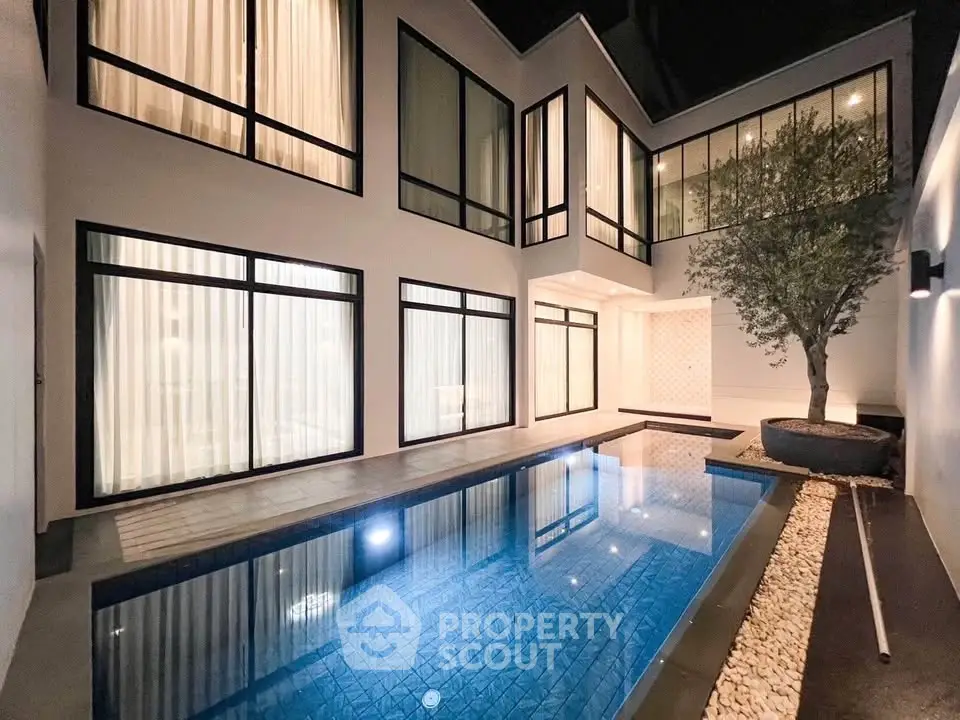 Luxurious modern home with private pool and elegant night lighting.