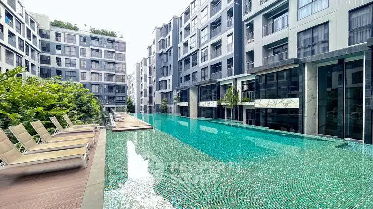 Luxurious modern apartment complex with stunning outdoor pool and sun loungers.