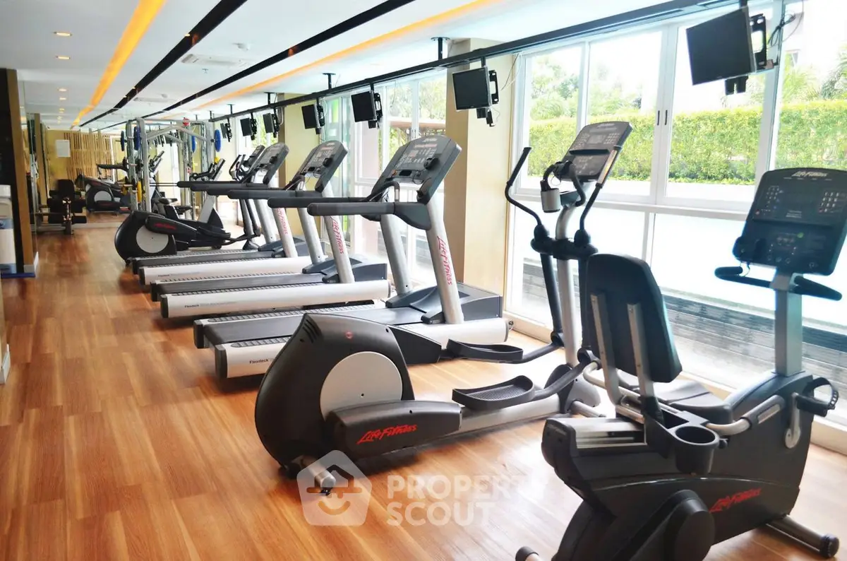 Modern gym with state-of-the-art equipment and large windows for natural light.