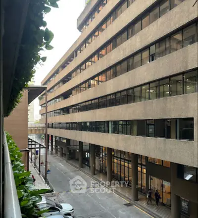 Modern office building exterior with large windows and street view