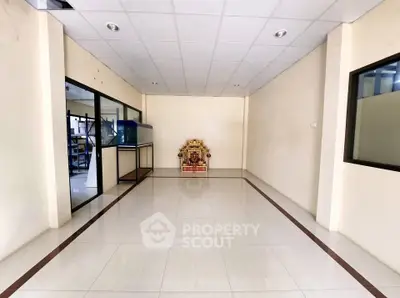 Spacious interior room with tiled flooring and glass partitions, ideal for office or retail space.