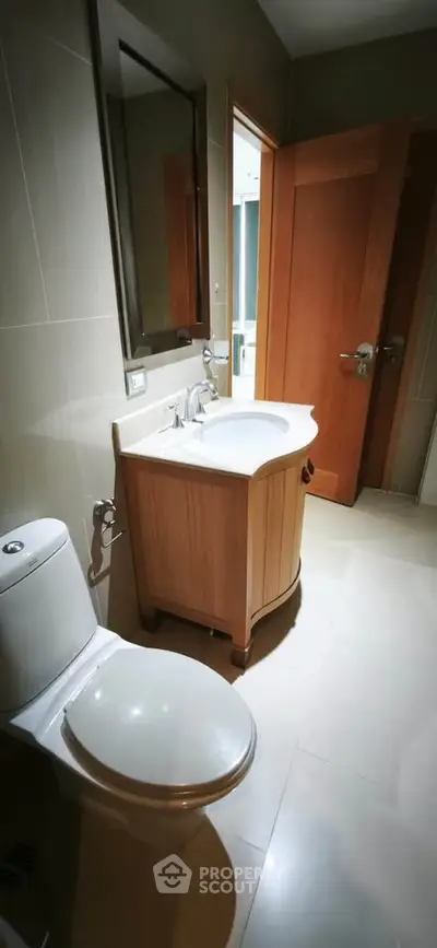 Modern bathroom with wooden vanity and sleek fixtures in a contemporary home.