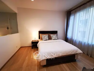 Modern bedroom with cozy lighting and large window, perfect for relaxation.