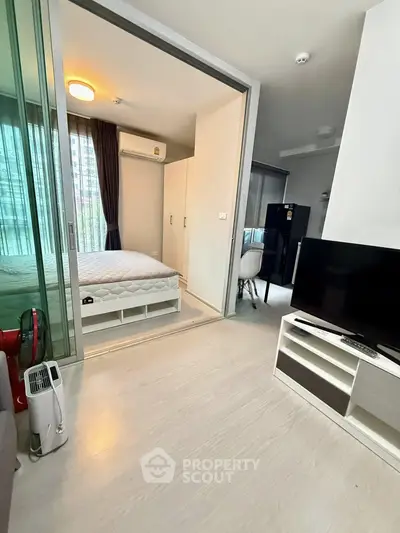 Modern apartment interior with open layout, featuring a cozy bedroom and living area with sleek furnishings.