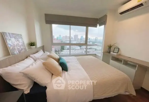 Cozy bedroom with city view and modern decor in high-rise apartment