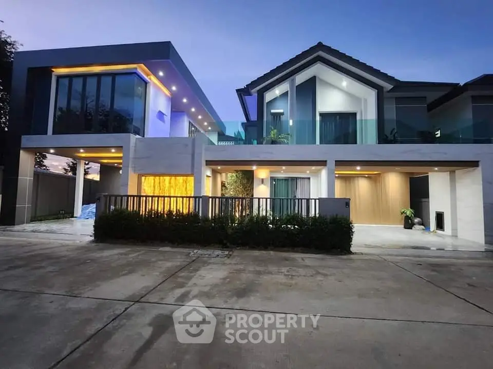 Stunning modern two-story house with elegant lighting and spacious driveway at dusk.