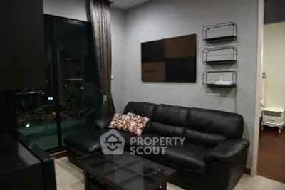 Modern living room with black leather sofa and city view balcony
