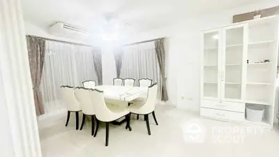 Elegant dining room with white furniture and large windows in modern home