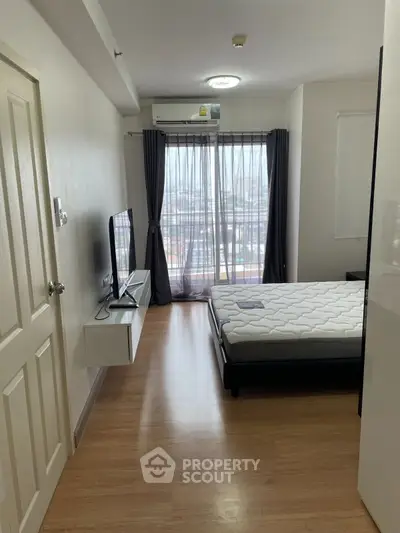 Modern bedroom with balcony view, featuring sleek furnishings and natural light.
