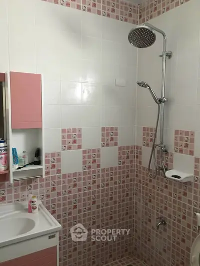 Charming bathroom with pink tile accents and modern shower fixtures