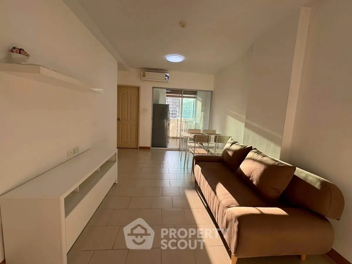Spacious living room with modern sofa and natural light in a cozy apartment.