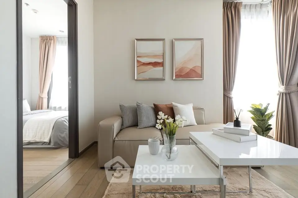 Elegant living room with modern decor and natural light, adjacent to cozy bedroom.