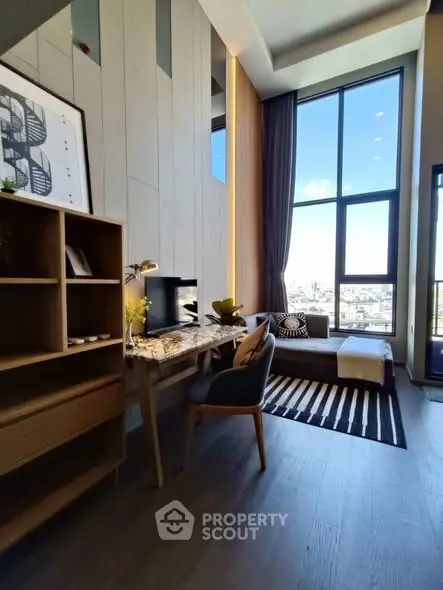 Modern living room with high ceilings and large windows offering a stunning city view.
